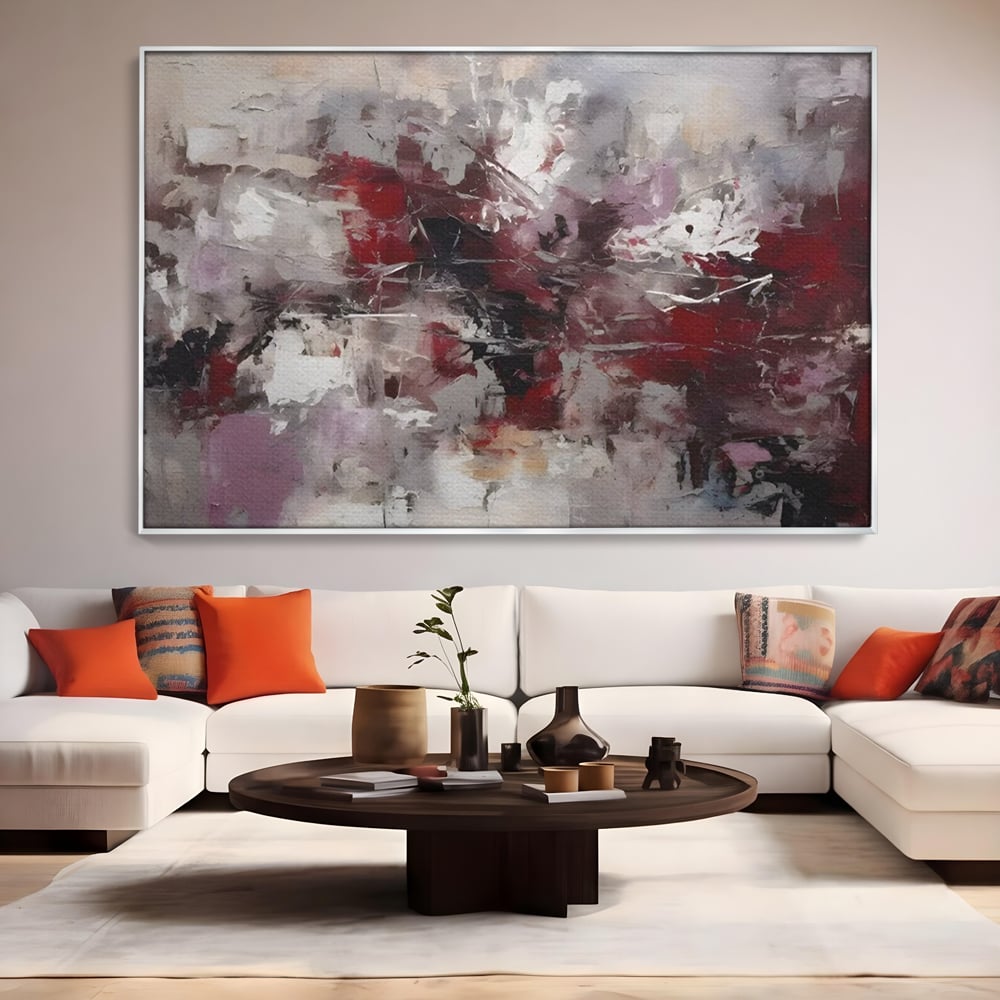 Tablou canvas cu pictura abstracta cu pete rosii, in rama de aluminiu argintiu, pe perete intr-un living